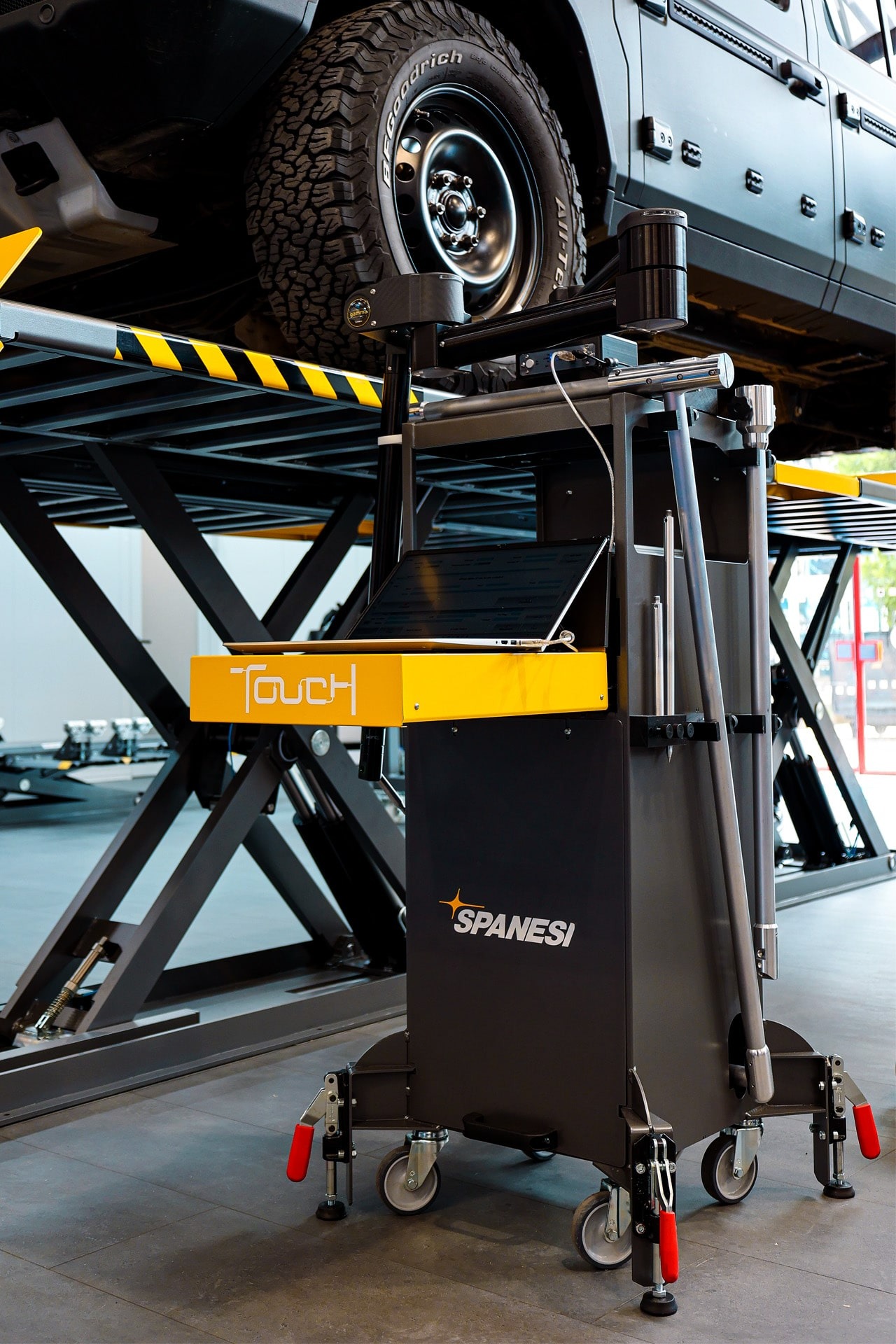 Spanesi Touch electronic measuring system beside a raised vehicle