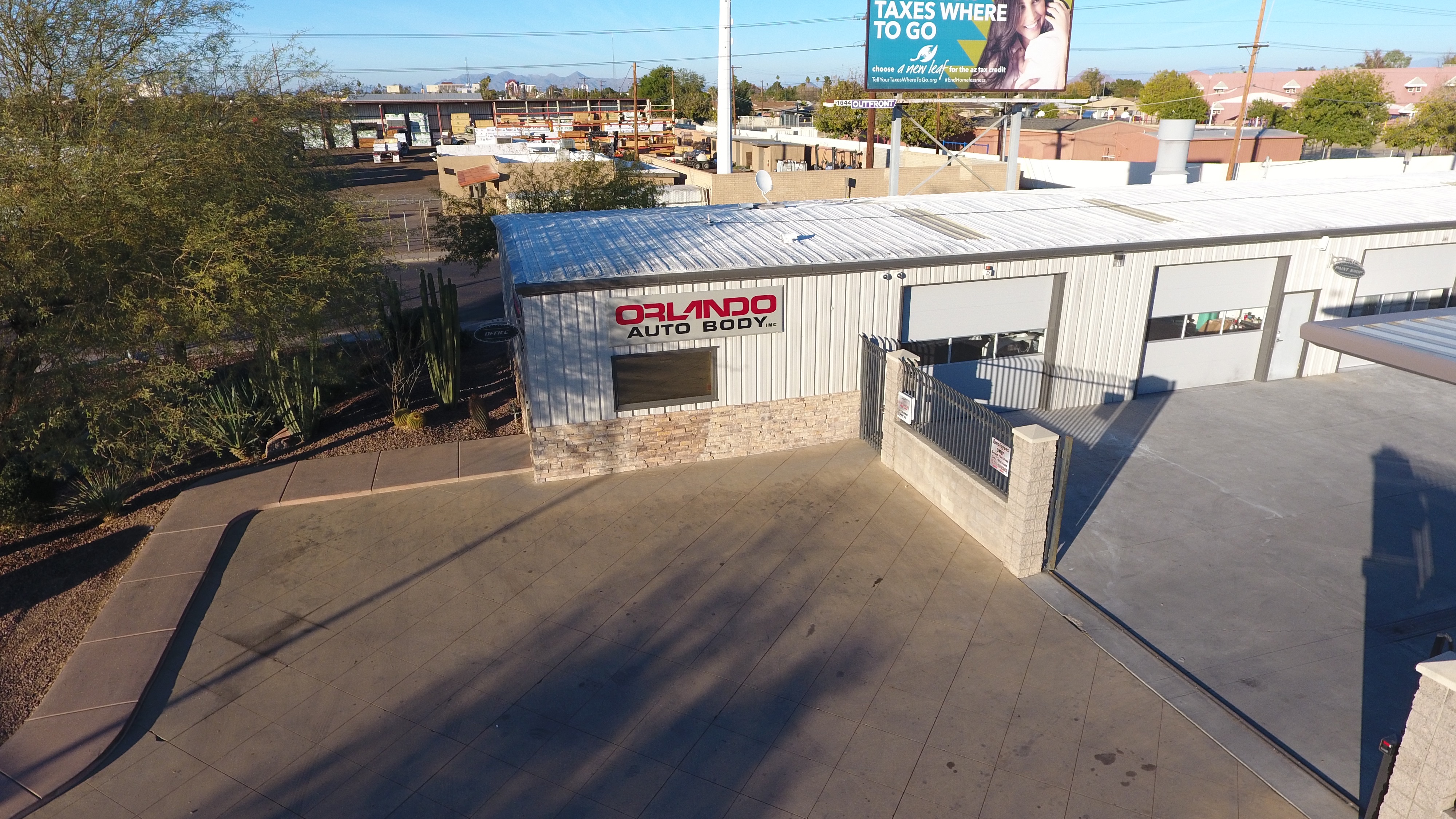 Aerial drone view of the Orlando Auto Body Mesa shop with storefront signage