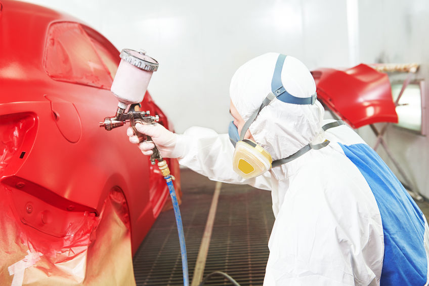 car painting in chamber auto body shop technician painting a car