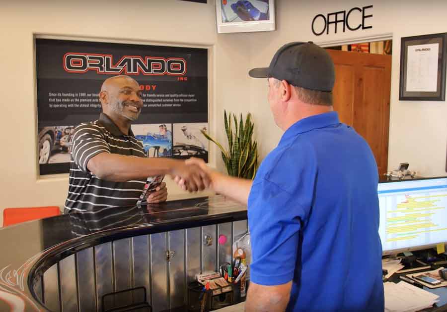 A customer being welcomed at the Orlando Auto Body front desk