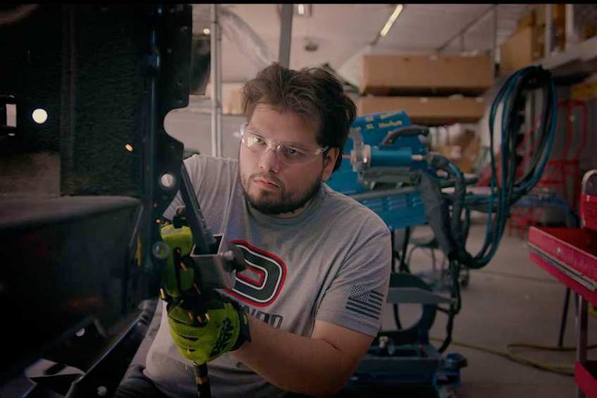 Collision repair technician working on a vehicle